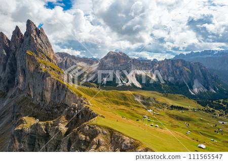 The steep slope of the rocky Seceda mountain covered with lush green grass in sunny cloudless day. The steep slope of the rocky Seceda mountain covered with lush green grass in sunny cloudless day. 111565547