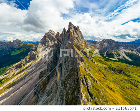 Aerial view of Seceda mountains with green cliffs in Italy in good sunny day Aerial view of Seceda mountains with green cliffs in Italy in good sunny day 111565571