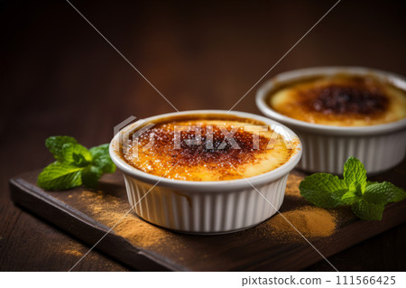 Two servings of creme brulee traditional French vanilla cream dessert on wooden board, rustic style 111566425