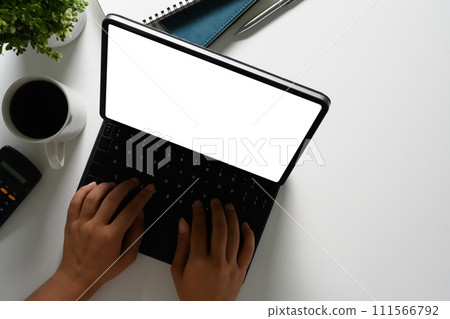Businessman hands typing, working with digital tablet on white office desk Businessman hands typing, working with digital tablet on white office desk 111566792