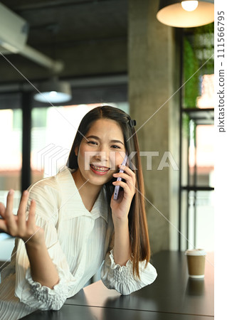 Portrait of smiling businesswoman having pleased phone conversation at coffee shop Portrait of smiling businesswoman having pleased phone conversation at coffee shop 111566795