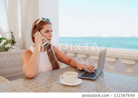 Woman coffee cafe macbook. Woman sitting at a coffee shop with mobile phone drinking coffee and looking away. Caucasian female relaxing at a cafe. 111567699
