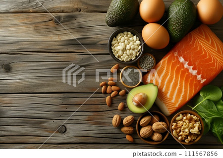 Top view of ketogenic diet essentials: avocados, nuts, seeds, eggs, and salmon on a wooden table. Healthy low carb products concept. 111567856