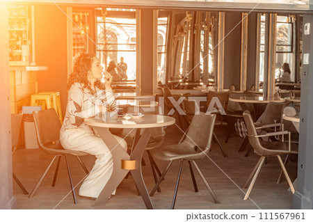 Woman cafe coffee breakfast. Portrait of an adult beautiful woman in an elegant suit in a cafe Woman cafe coffee breakfast. Portrait of an adult beautiful woman in an elegant suit in a cafe 111567961