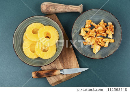 Dry and fresh pineapples in bowls Dry and fresh pineapples in bowls 111568548