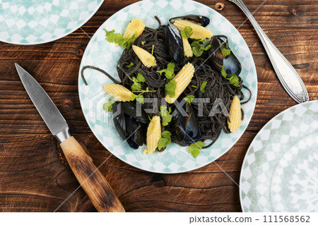 Black pasta with mussels and corn. 111568562