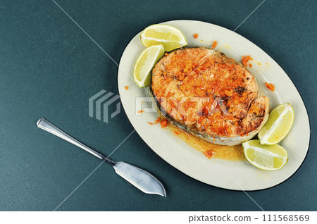 Salmon or trout steak in orange marinade. 111568569