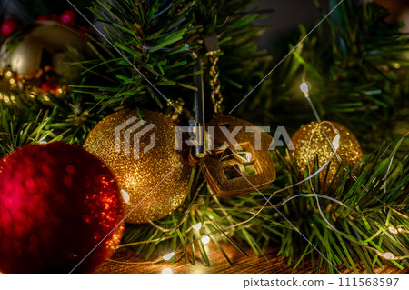 Gift key house with a keychain backdrop of Christmas tree. Building, design, project, moving to new house, mortgage, rent and purchase real estate. A gift for New Year, Christmas Gift key house with a keychain backdrop of Christmas tree. Building, design, project, moving to new house, mortgage, rent and purchase real estate. A gift for New Year, Christmas 111568597
