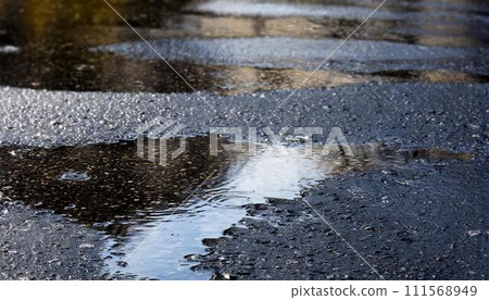 濕瀝青上的水坑。 111568949