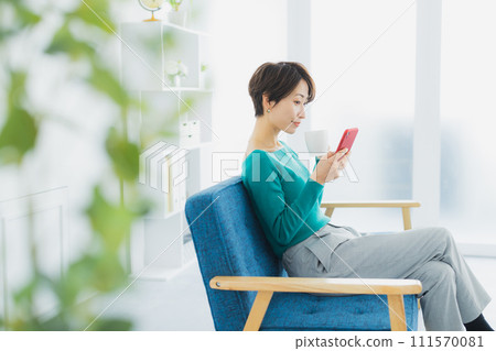 A woman watching a smartphone A woman watching a smartphone 111570081