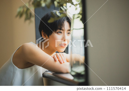 一個女人在窗邊看日落 111570414