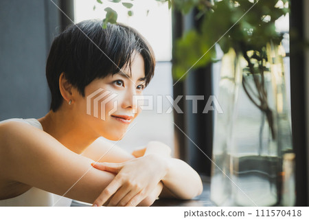 一個女人在窗邊看日落 一個女人在窗邊看日落 111570418