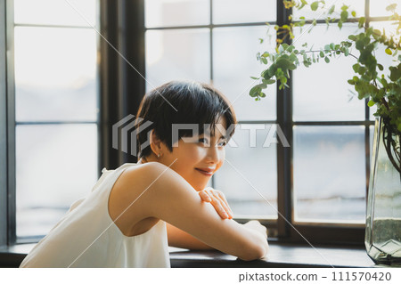 A woman watching the sunset by the window A woman watching the sunset by the window 111570420