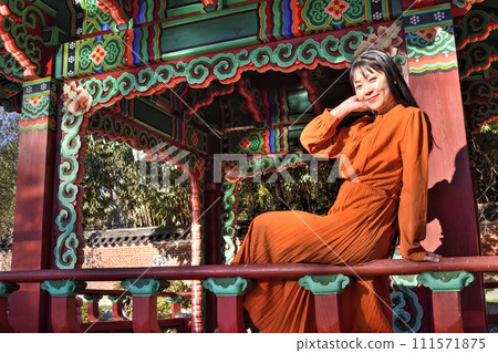 A woman sitting on the railing of a Korean restaurant A woman sitting on the railing of a Korean restaurant 111571875