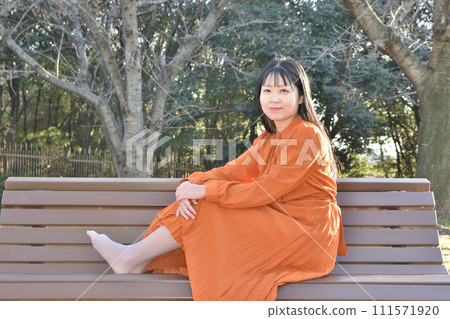 A woman sitting on a bench A woman sitting on a bench 111571920
