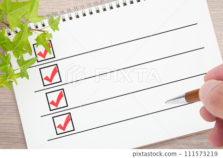 In the hands of the person writing on the checklist In the hands of the person writing on the checklist 111573219