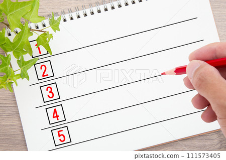 In the hand of the person writing on the list In the hand of the person writing on the list 111573405