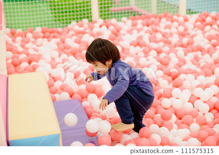 Boy playing in the ball pool 111575315