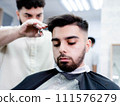 Man in barber shop getting haircut for his hair, beard, and eyebrows 111576279