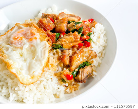 Rice topped with crispy pork belly with Thai basil and fried egg Rice topped with crispy pork belly with Thai basil and fried egg 111576597