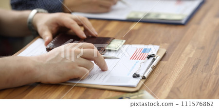 Male hands in suit lie on application for usa visa 111576862