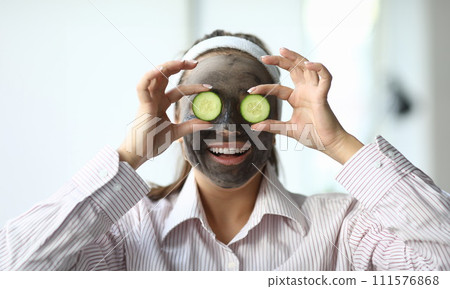 Girl with cosmetic mask on face cucumbers in eyes 111576868