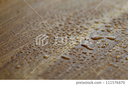 Drops water are sprayed on dark wooden surface Drops water are sprayed on dark wooden surface 111576870