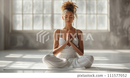 girl in lotus position meditating in studio 111577052