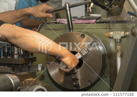 The machine operator set up the work pieces on lathe machine. 111577188