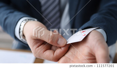 Closeup man in suit hiding ace card in sleeve Closeup man in suit hiding ace card in sleeve 111577201