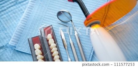 Dental instruments and dentures lying on sterile medical napkin in clinic closeup Dental instruments and dentures lying on sterile medical napkin in clinic closeup 111577253