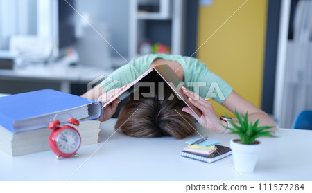 Woman covered her head with laptop and put it on table at workplace 111577284