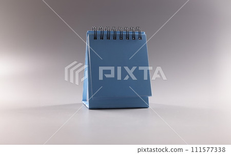 Desktop blue paper calendar for 2022 on gray background closeup Desktop blue paper calendar for 2022 on gray background closeup 111577338