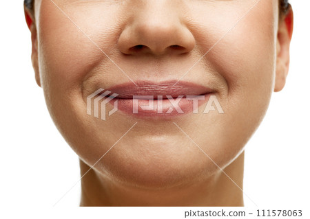 Cropped portrait of middle-aged woman with full moisturized pink lips and well-kept skin. Model smiling. Prevention of nasolabial folds. 111578063