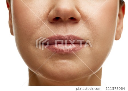 Cropped portrait of middle-aged woman with full moisturized pink lips with natural gloss and well-kept skin. Prevention of nasolabial folds. 111578064