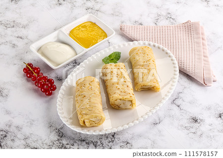 Homemade stuffed pancakes with honey and cream sour Homemade stuffed pancakes with honey and cream sour 111578157