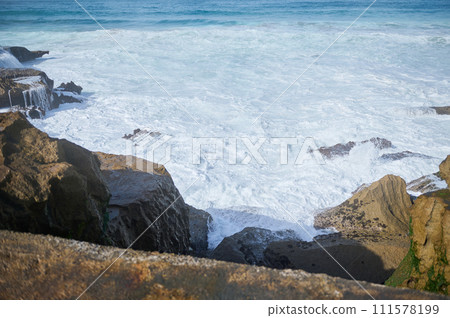Nature background waves crashing coast, making white foam while breaking on rocky beach. Slow motion Nature background waves crashing coast, making white foam while breaking on rocky beach. Slow motion 111578199