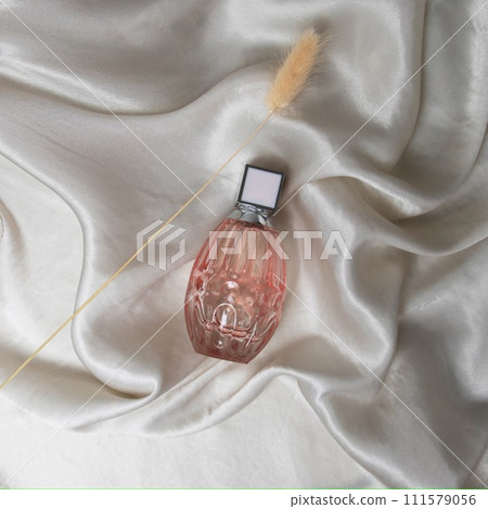 A bottle of perfume in pink glass on a background 111579056
