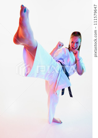 Top view portrait of karate fighter, master, woman shouting and training in action isolated over white studio background. 111579647