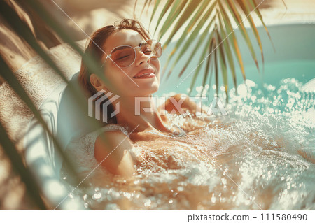 Woman relaxing in outdoor spa bath on tropical resort. Enjoying summer vacation in jacuzzi on the beach. Travel and holiday concept. Spa swimming pool, wellness and self-care, hotel luxury relax 111580490