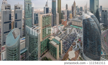 Skyline view of the high-rise buildings on Sheikh Zayed Road in Dubai aerial night to day timelapse, UAE. 111581311