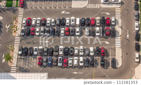 Aerial view of many colorful cars parked on parking lot with lines and markings for parking places all day timelapse. Dubai Aerial view of many colorful cars parked on parking lot with lines and markings for parking places all day timelapse. Dubai 111581353