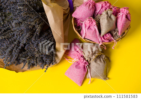 Dried lavender flowers and sachets on a yellow background. Dried lavender flowers and sachets on a yellow background. 111581583
