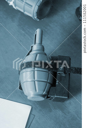Prototype model of grenade ammunition printed on 3D printer. Small models of grenade defensive weapon printed on 3D printer from molten plastic on table. New modern innovation printing technology Prototype model of grenade ammunition printed on 3D printer. Small models of grenade defensive weapon printed on 3D printer from molten plastic on table. New modern innovation printing technology 111582001