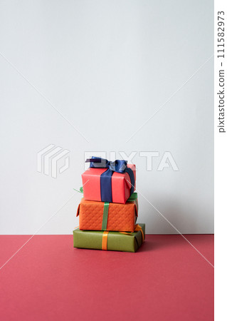 Stack of gift boxes on red desk. gray wall background 111582973