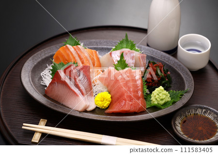 什錦生魚片。鮪魚、中脂鮪魚、鮭魚、鰤魚和鯛魚。傳統的日本料理。 什錦生魚片。鮪魚、中脂鮪魚、鮭魚、鰤魚和鯛魚。傳統的日本料理。 111583405