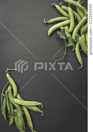 Fresh green peas on wooden table. Vegan food. Green peas seeds in pods. peas. Flat lay. Top view. Fresh green peas on wooden table. Vegan food. Green peas seeds in pods. peas. Flat lay. Top view. 111583549