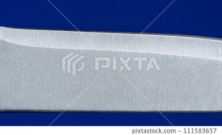 Knife blade close up, isolated on a blue background Knife blade close up, isolated on a blue background 111583657