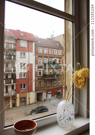 View from the window to the street with a colorful old house View from the window to the street with a colorful old house 111585284