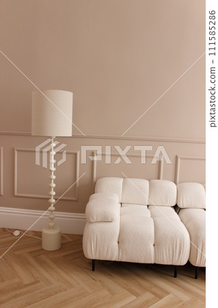 a light beige sofa and a table lamp as part of the interior 111585286